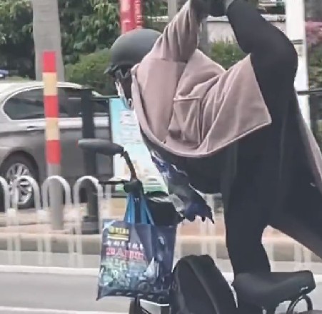 女子“练瑜伽”式骑车惊呆路人，网友：金鸡独立练瑜伽！